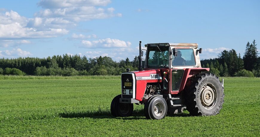 Trattore Massey Ferguson con falciatrice a dischi montata posteriormente al lavoro in un prato